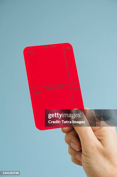 close up of man's hand showing  red card, studio shot - referee stock pictures, royalty-free photos & images
