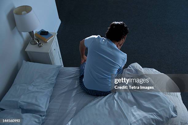 usa, new jersey, jersey city, man sitting on bed - wake up foto e immagini stock