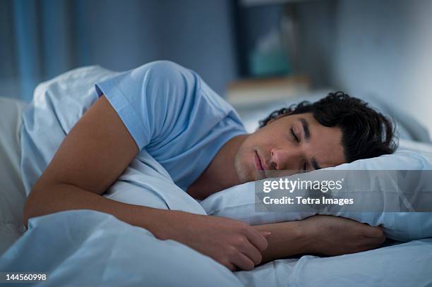 usa, new jersey, jersey city, man sleeping in bed - lying on side stock-fotos und bilder