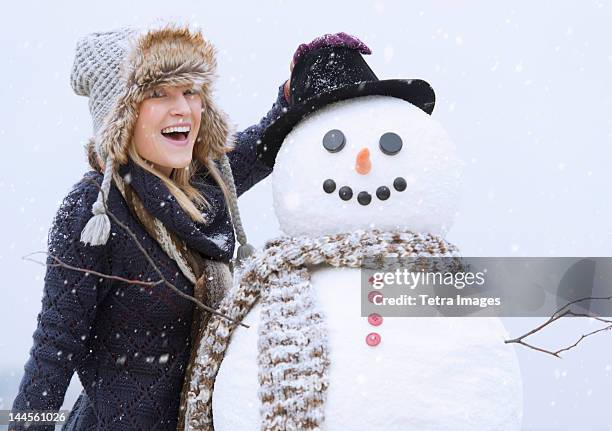 usa, new jersey, jersey city, portrait of woman with snowman - frau schneemann stock-fotos und bilder