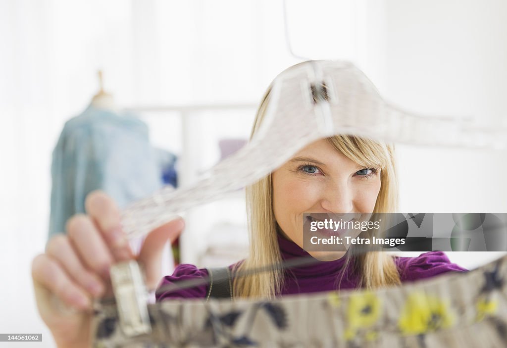 USA, New Jersey, Jersey City, Woman looking at skirt in clothes store