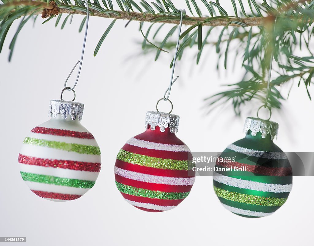 Studio shot of striped Christmas ornaments hanging on Christmas tree