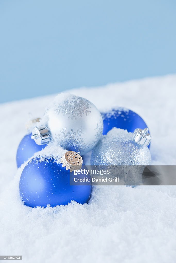 Studio shot of blue and silver christmas ornament on snow