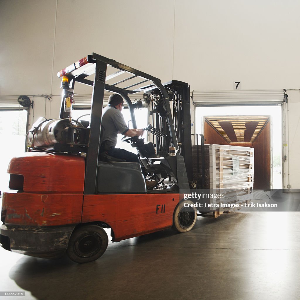 USA, California, Santa Ana, Forklift driver working in warehouse