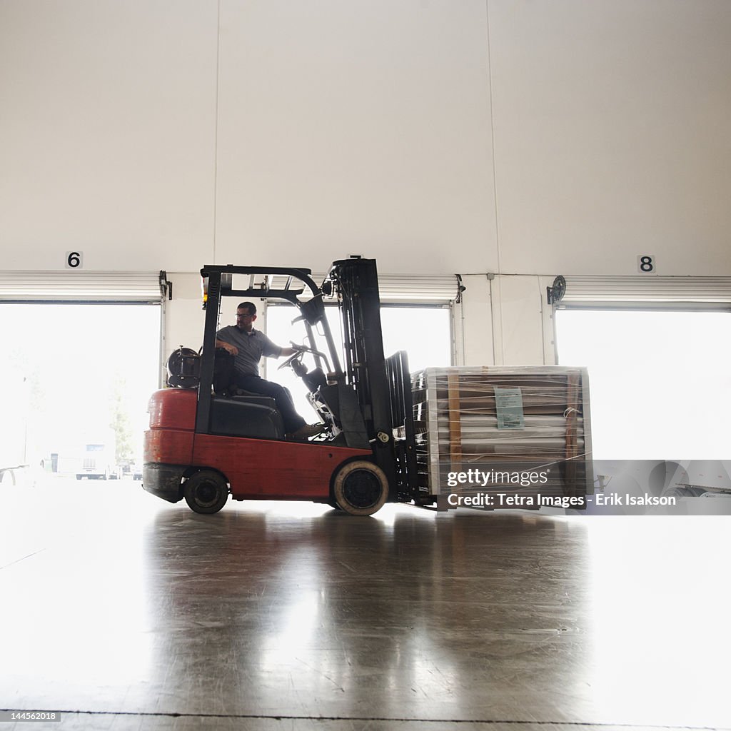 USA, California, Santa Ana, Forklift driver working in warehouse