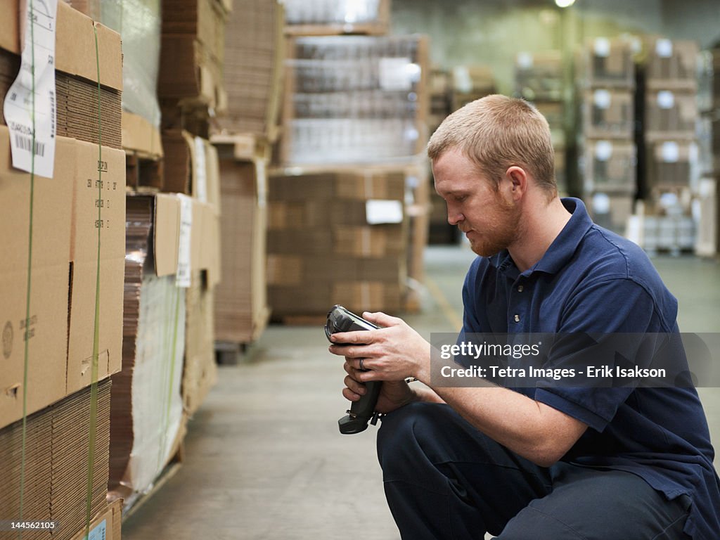 USA, California, Santa Ana, Warehouse worker scanning delivery