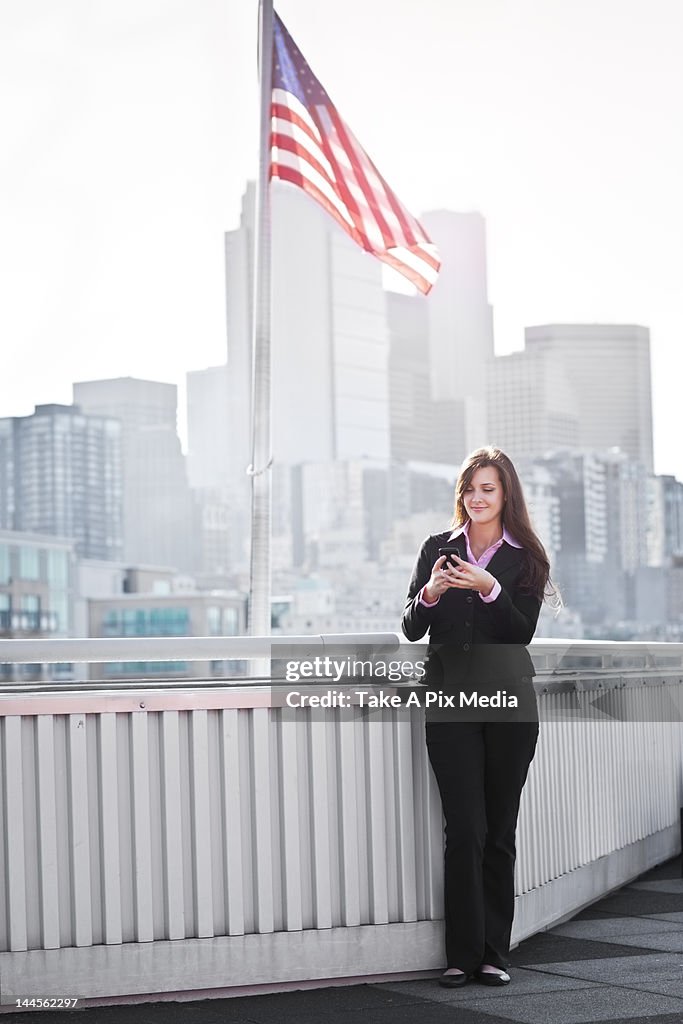 USA, Seattle, Smiling young businesswoman using mobile