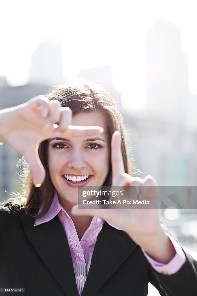 USA, Seattle, Smiling businesswoman making frame with hands