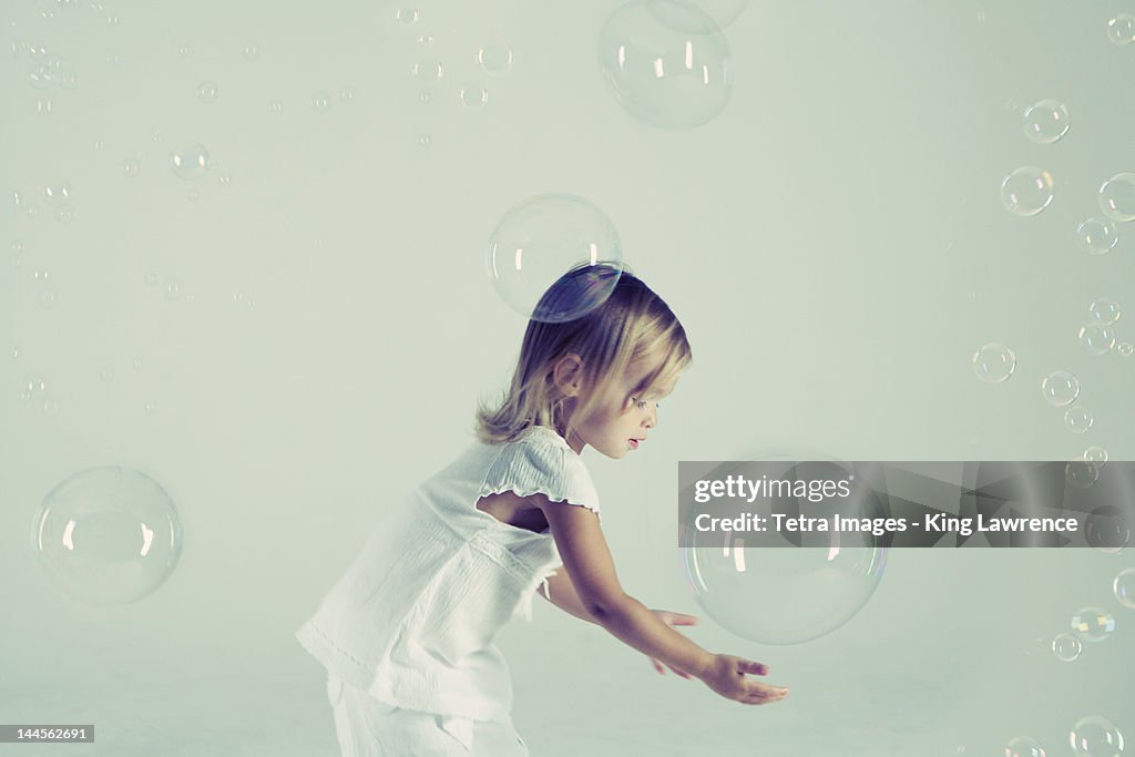 Studio shot of girl playing with bubbles