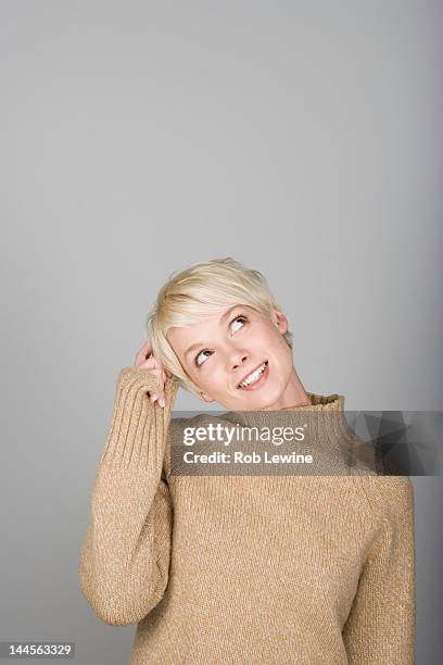 studio shot portrait of young woman scratching head, waist up - smiling woman waist up stock pictures, royalty-free photos & images