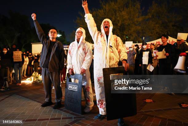 Demonstrator yells while speaking to the crowd at a candlelight vigil at University of Southern California honoring those who perished in an...