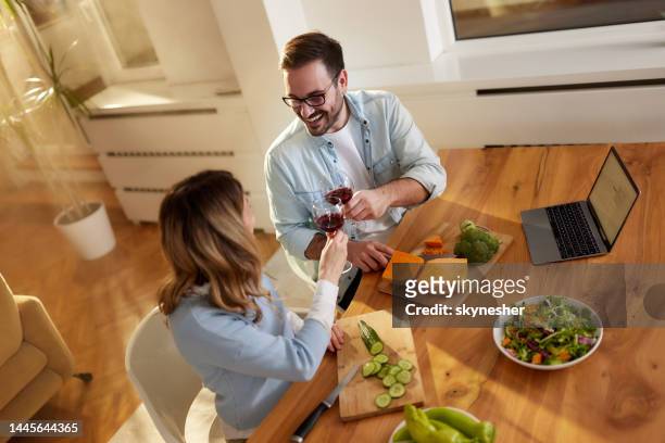 oben blick auf ein glückliches paar, das im speisesaal mit wein anstößt. - wein und kochen stock-fotos und bilder