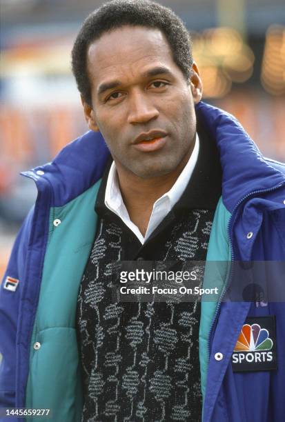 Football Analyst O.J. Simpson looks on before the start of an NFL football game circa 1991.