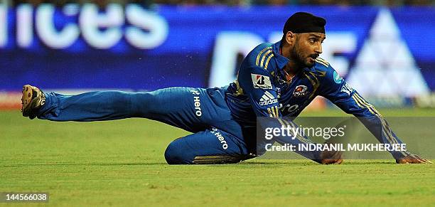 Mumbai Indians captain Harbhajan Singh dives to save a shot by unseen Kolkata Knight Riders batsman Manoj Tiwary during the IPL Twenty20 cricket...