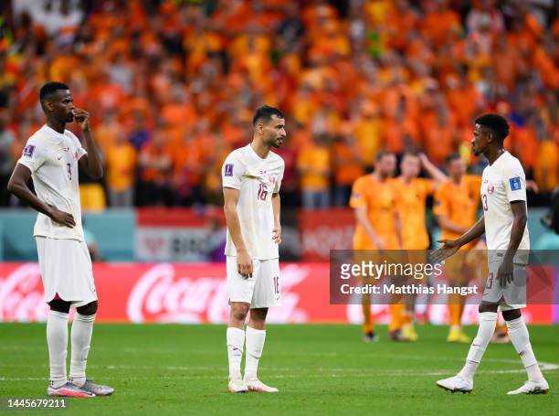 Mohammed Muntari, Boualem Khoukhi and Musaab Khidir of Qatar show their disappointment after the FIFA World Cup Qatar 2022 Group A match between...