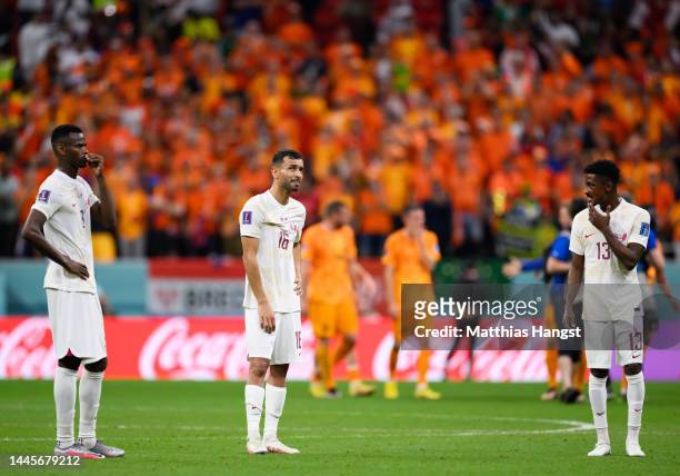 Mohammed Muntari, Boualem Khoukhi and Musaab Khidir of Qatar show their disappointment after the FIFA World Cup Qatar 2022 Group A match between...