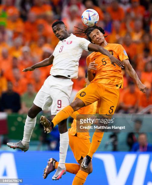 Mohammed Muntari of Qatar jumps for a header with Nathan Ake of Netherlands during the FIFA World Cup Qatar 2022 Group A match between Netherlands...