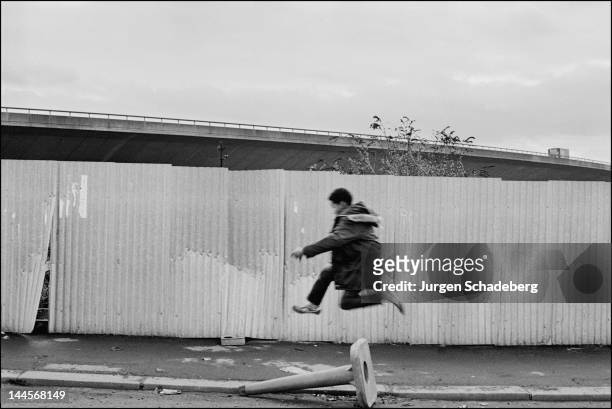 Boy jumps down the street under the Westway in Edgware Road, London, 1972.
