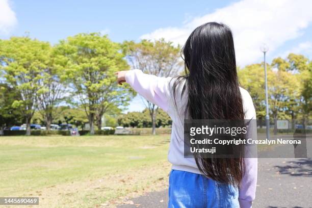 back view of girl with a very long hair,pointing direction - child pointing stock pictures, royalty-free photos & images