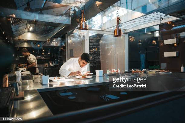 chef preparing a plate in a gourmet restaurant - chef kitchen stockfoto's en -beelden