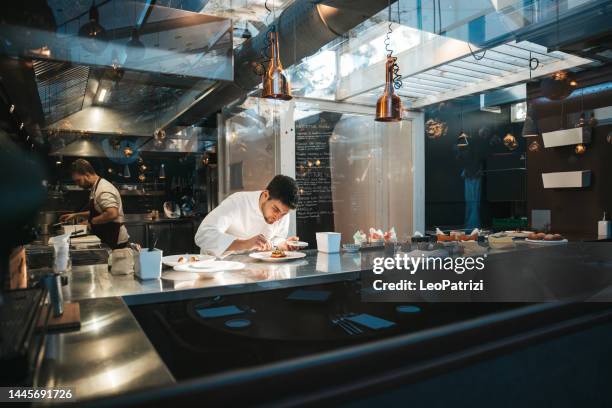 chef preparing a plate in a gourmet restaurant - cook restaurant stock pictures, royalty-free photos & images