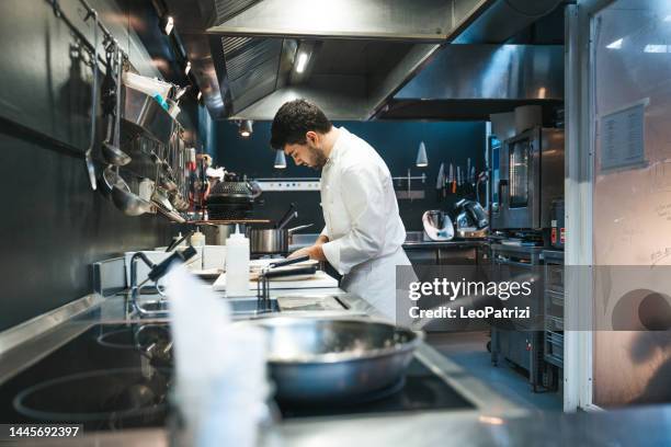 koch kocht in einem luxusrestaurant - restaurant kitchen stock-fotos und bilder
