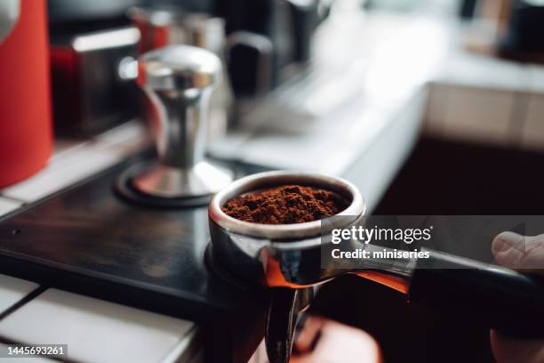 foto ravvicinata sulla mano dell'uomo che tiene un portafiltro in una caffetteria - caffettiera foto e immagini stock