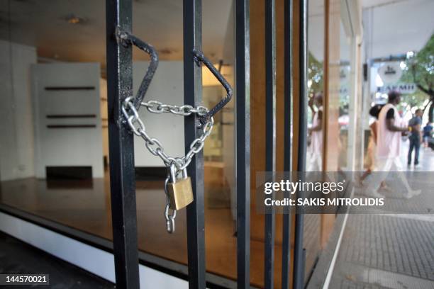Closing shop with a lock in the door in Thessaloniki on 9 September, 2011.AFP PHOTO/Sakis Mitrolidis