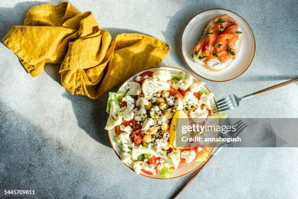 smoked salmon and cream cheese toast with a chickpea, feta, cucumber, cauliflower, tomato and sesame seed salad - chevre animal stock pictures, royalty-free photos & images