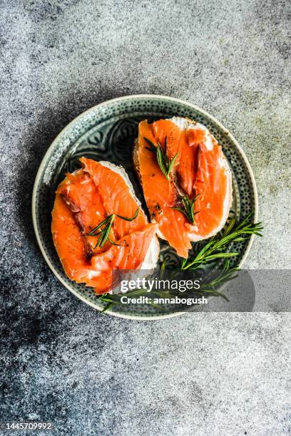 overhead view of two smoked salmon and cream cheese toasts with rosemary - lunch cheese imagens e fotografias de stock