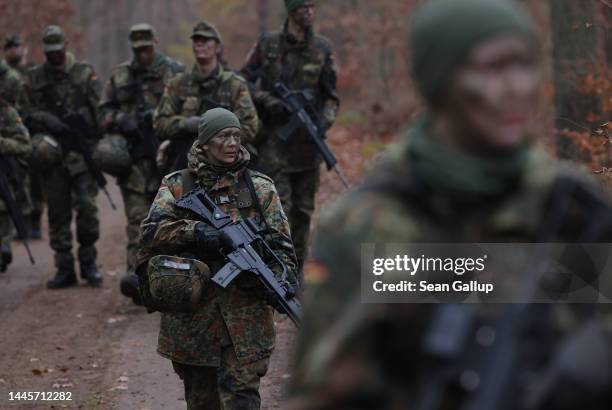 New female army recruit of the Bundeswehr, Germany's armed forces, are armed with Heckler & Koch G36 assault rifles as they lead a patrol in basic...