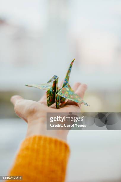 female hand hold origame crane - sin esperanza fotografías e imágenes de stock