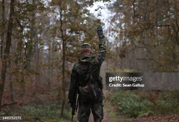 An instructor signals while leading new army recruits of the Bundeswehr, Germany's armed forces, in basic training in a forest on November 29, 2022...
