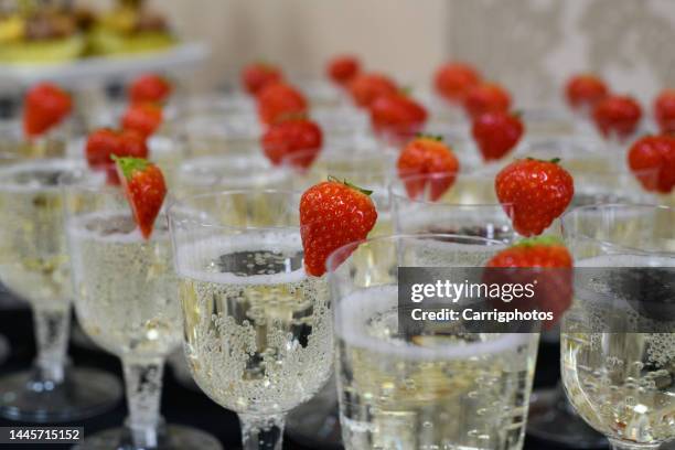 close-up of rows of champagne glasses with strawberry garnish - prosecco stock pictures, royalty-free photos & images