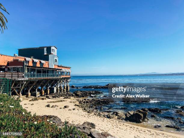 converted cannery building on pier against blue sky in monterey, california - cidade de monterey califórnia - fotografias e filmes do acervo