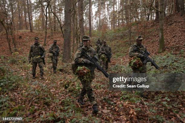 New female army recruit of the Bundeswehr, Germany's armed forces, co-leads a patrol in basic training in a forest on November 29, 2022 near...