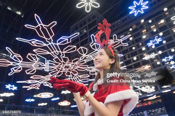 Girl poses with illuminated decorations during Tsim Sha Tsui East Festive Illuminations Switch-on Ceremony 2022 on November 29, 2022 in Hong Kong,...