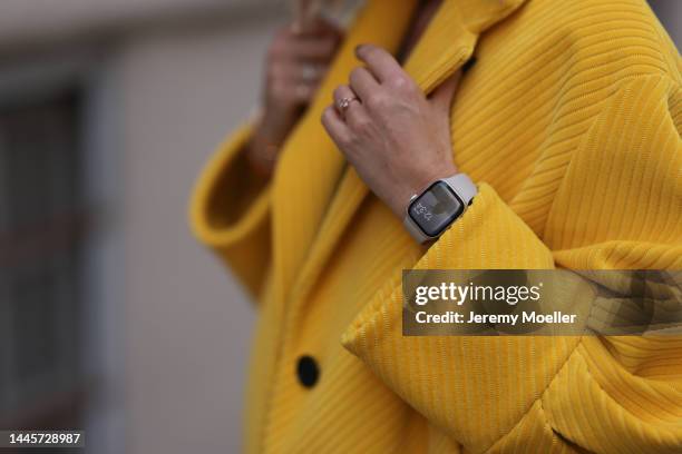 Karin Teigl is seen wearing Prada yellow long coat and silver Apple Watch, on November 25, 2022 in Vienna, Austria.