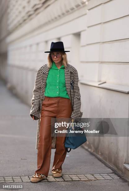 Karin Teigl is seen wearing Nomads Modern black hat, Milk green knit cardigan, Gucci NY Yankees beige checked coat, Gestuz brown leather pants, JW...