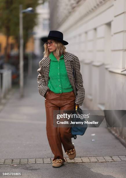 Karin Teigl is seen wearing Nomads Modern black hat, Milk green knit cardigan, Gucci NY Yankees beige checked coat, Gestuz brown leather pants, JW...