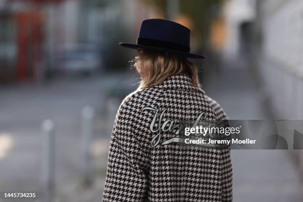Karin Teigl is seen wearing Nomads Modern black hat and Gucci NY Yankees beige checked coat, on November 25, 2022 in Vienna, Austria.