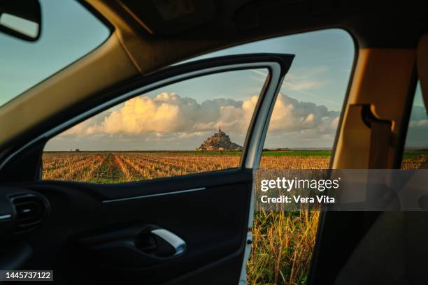 cropped landscape with nobody framed in car window with mont saint michel abbey in background. - car back view bildbanksfoton och bilder