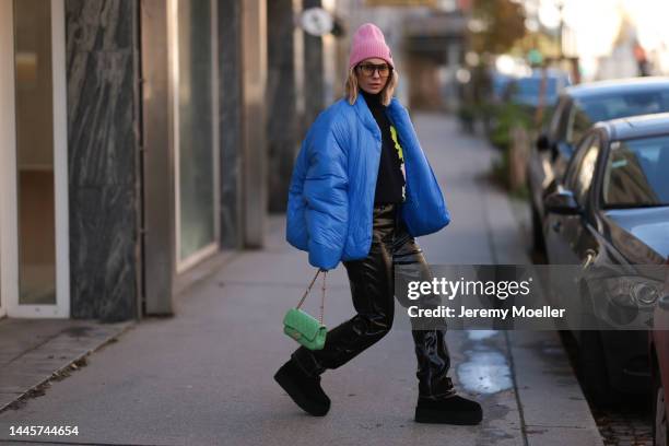 Karin Teigl is seen wearing Louis Vuitton pink wool hat, Chanel light green bag, Dior sunglasses, Gap x Yeezy blue puffer jacket, H&M Studio black...