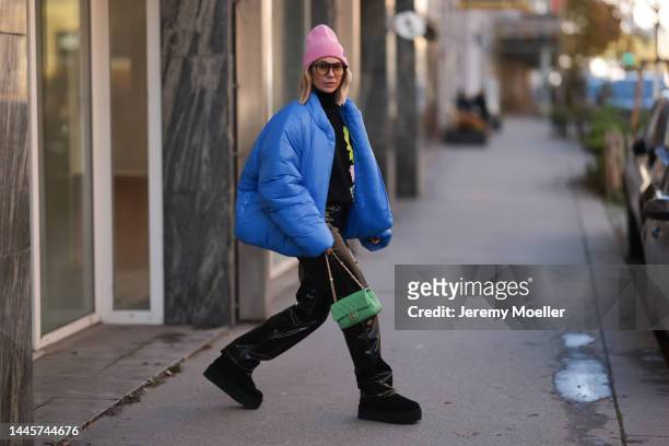 Karin Teigl is seen wearing Louis Vuitton pink wool hat, Chanel light green bag, Dior sunglasses, Gap x Yeezy blue puffer jacket, H&M Studio black...