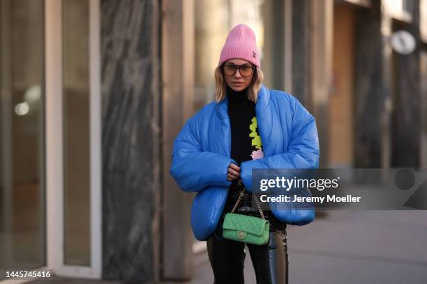 Karin Teigl is seen wearing Louis Vuitton pink wool hat, Chanel light green bag, Dior sunglasses, Gap x Yeezy blue puffer jacket, H&M Studio black...