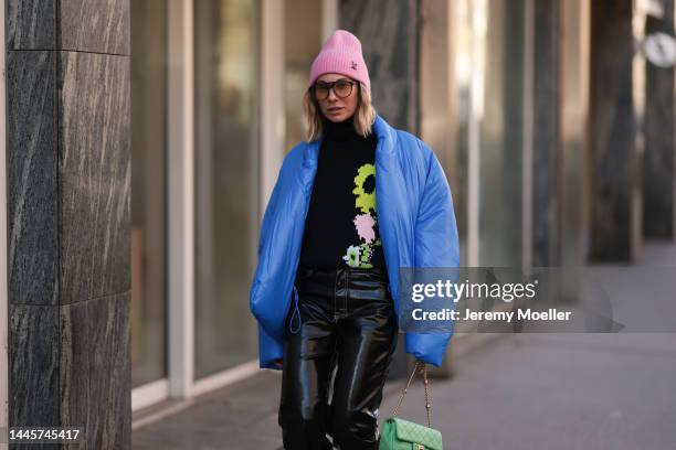 Karin Teigl is seen wearing Louis Vuitton pink wool hat, Chanel light green bag, Dior sunglasses, Gap x Yeezy blue puffer jacket, H&M Studio black...