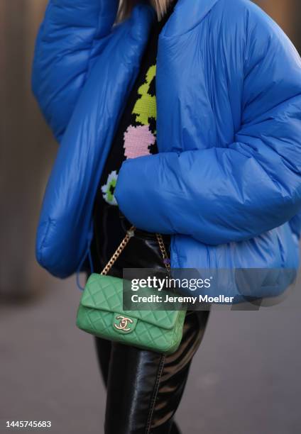 Karin Teigl is seen wearing Chanel light green bag, Gap x Yeezy blue puffer jacket, H&M Studio black flower pattern sweater and H&M black vinyl...