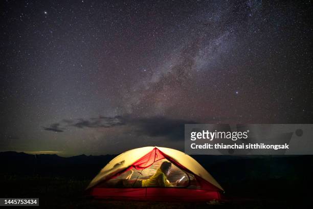 asian female camping at night with under the milky way. - zelt nacht stock-fotos und bilder