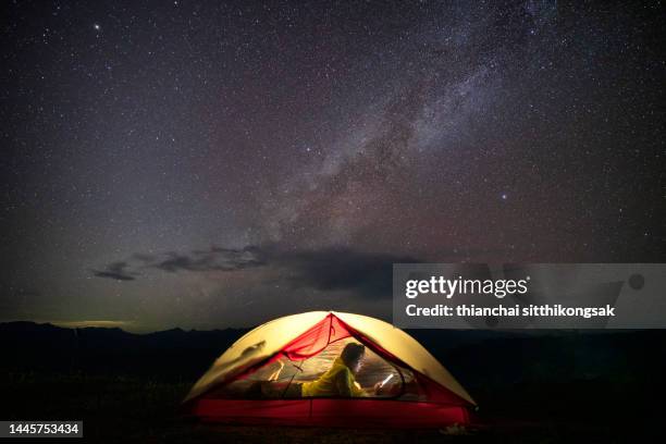 asian female camping at night with under the milky way. - wilderness camping stock pictures, royalty-free photos & images