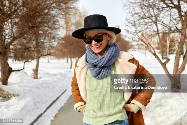 happy senior woman happy on autumn street - sheepskin stock pictures, royalty-free photos & images
